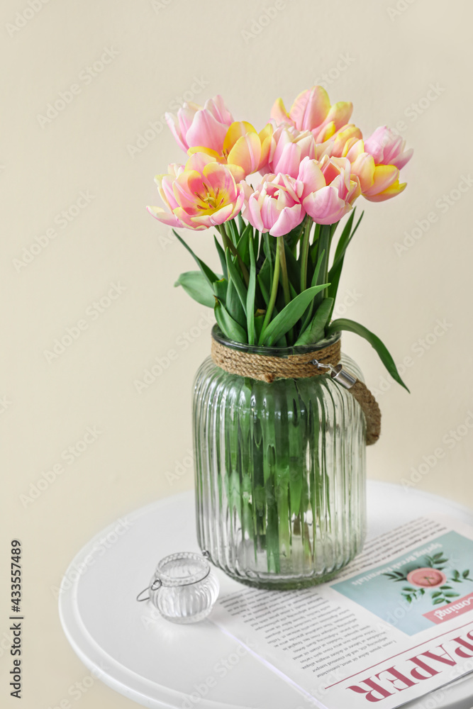 Bouquet of beautiful tulip flowers on table near color wall