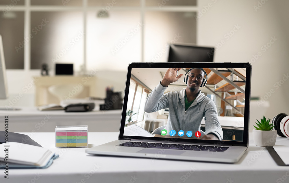 Laptop computer with a video call from businessman lying on desk