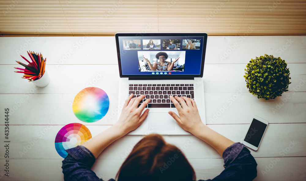 Caucasian businesswoman sitting at desk using laptop having video call with group of colleagues