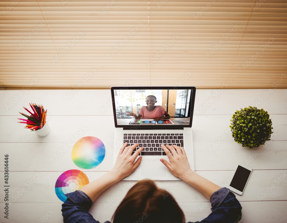 Caucasian businesswoman sitting at desk using laptop having video call with female colleague