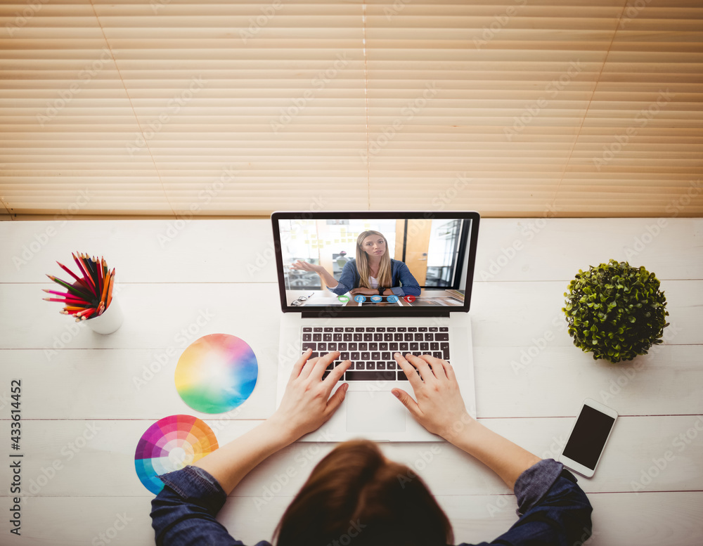 Caucasian businesswoman sitting at desk using laptop having video call with female colleague