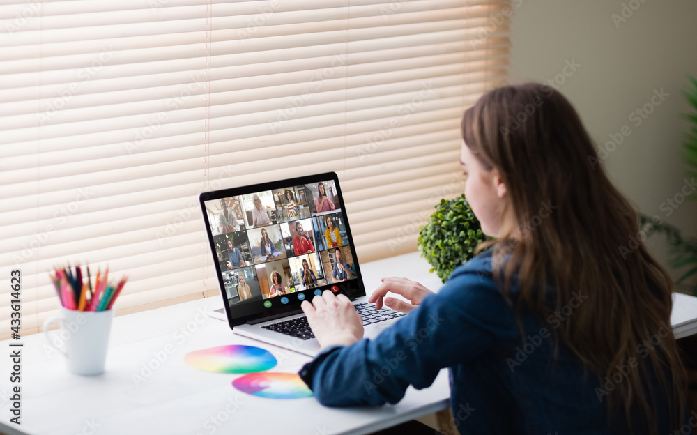 Caucasian businesswoman sitting at desk using laptop having video call with group of colleagues