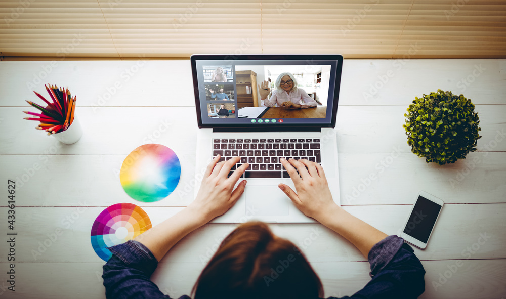 Caucasian businesswoman sitting at desk using laptop having video call with group of colleagues