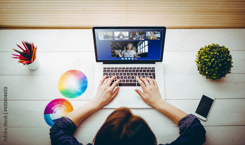 Caucasian businesswoman sitting at desk using laptop having video call with group of colleagues