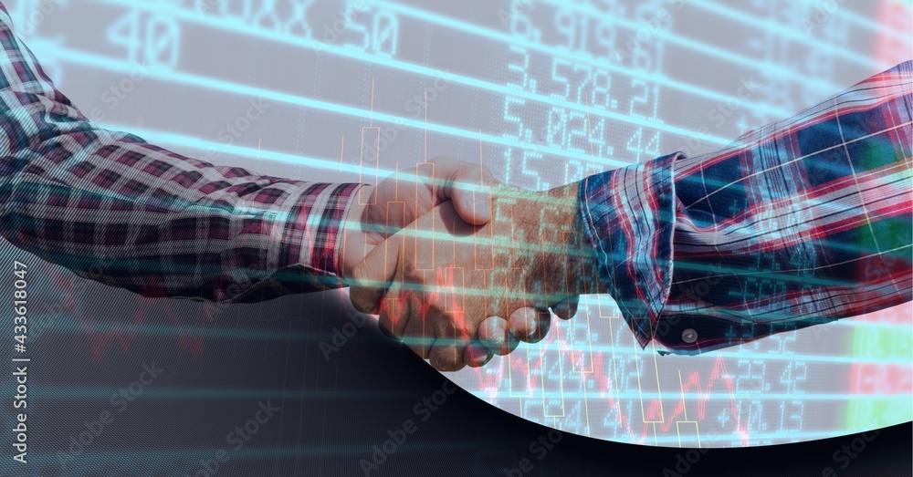 Stock market data processing against mid section of two businessmen shaking hands