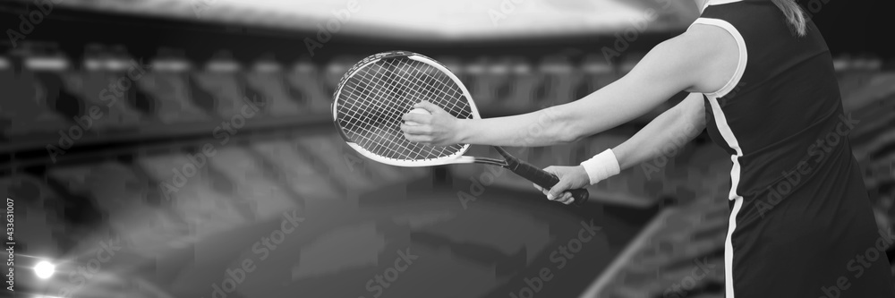 Composition of midsection of woman playing tennis over sports stadium in black and white