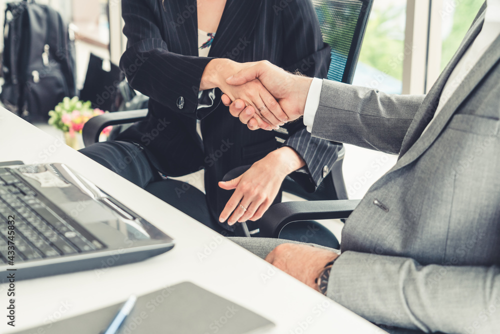 Businessman executive handshake with businesswoman worker in modern workplace office. People corpora