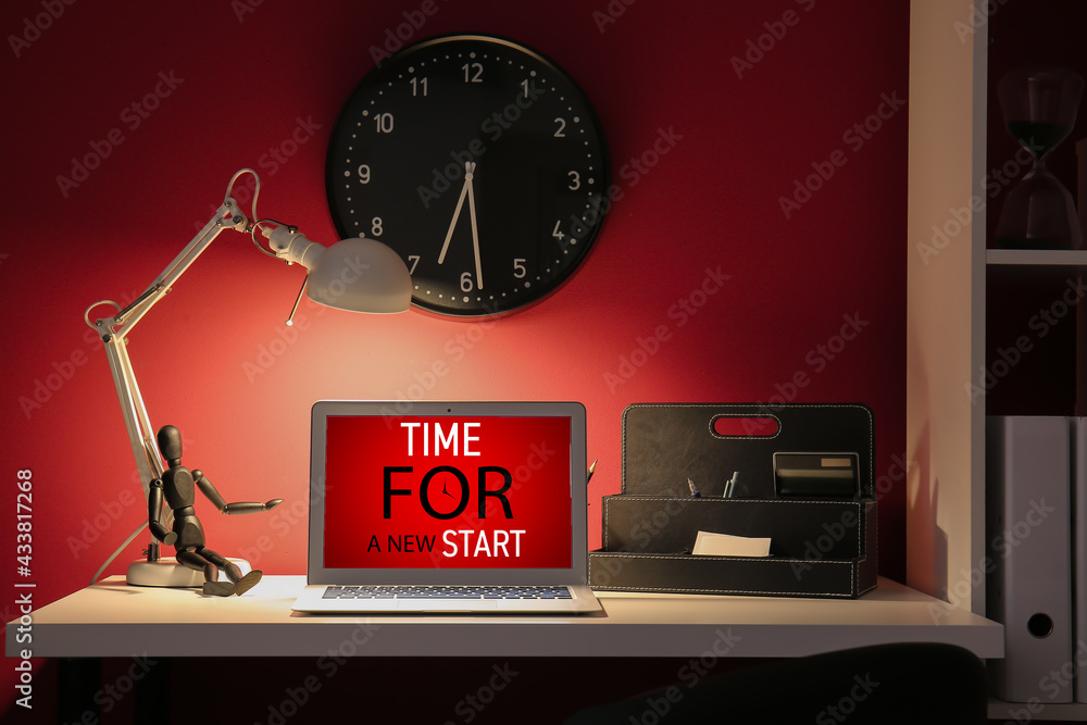 Text TIME FOR A NEW START on screen of laptop at workplace in office