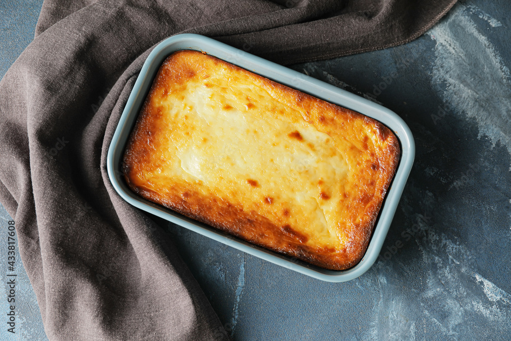 Dish with tasty cottage cheese casserole on color background