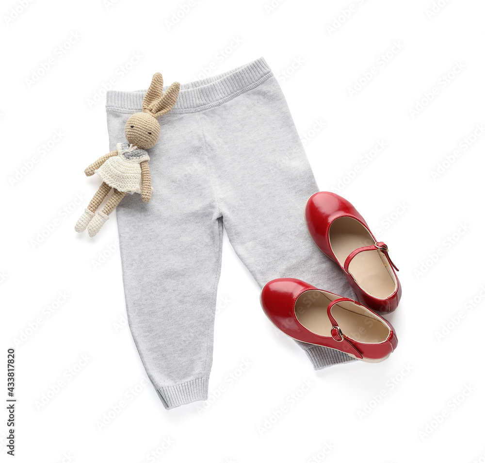 Childs pants, shoes and toy on white background