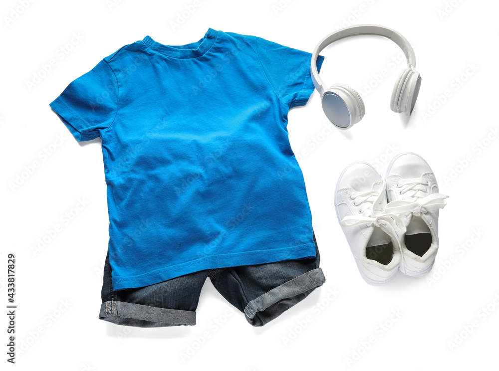 Childs clothes and headphones on white background