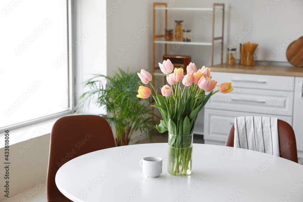 Bouquet of beautiful tulip flowers on table in kitchen