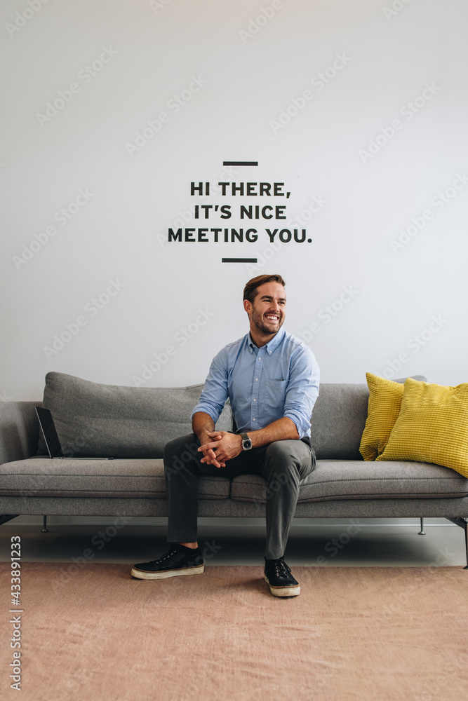 Positive male executive on sofa at lobby