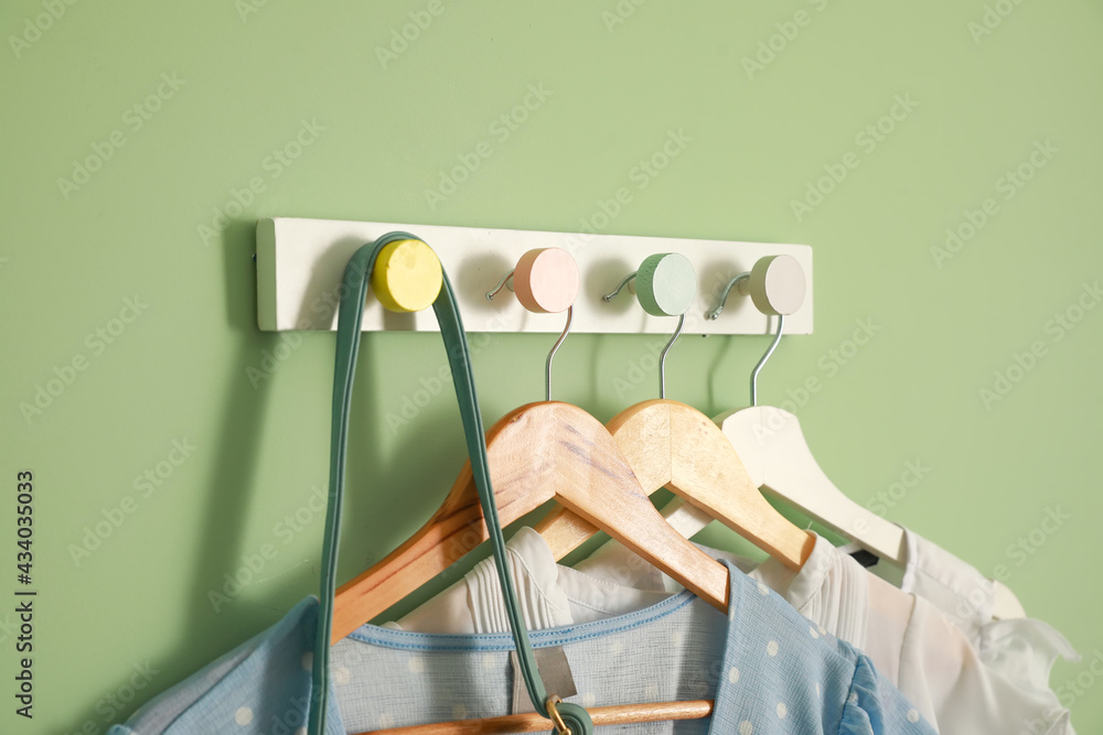 Hanger with stylish clothes on color background, closeup