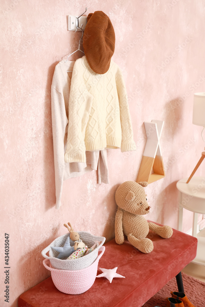 Interior of modern dressing room with stylish clothes and toys