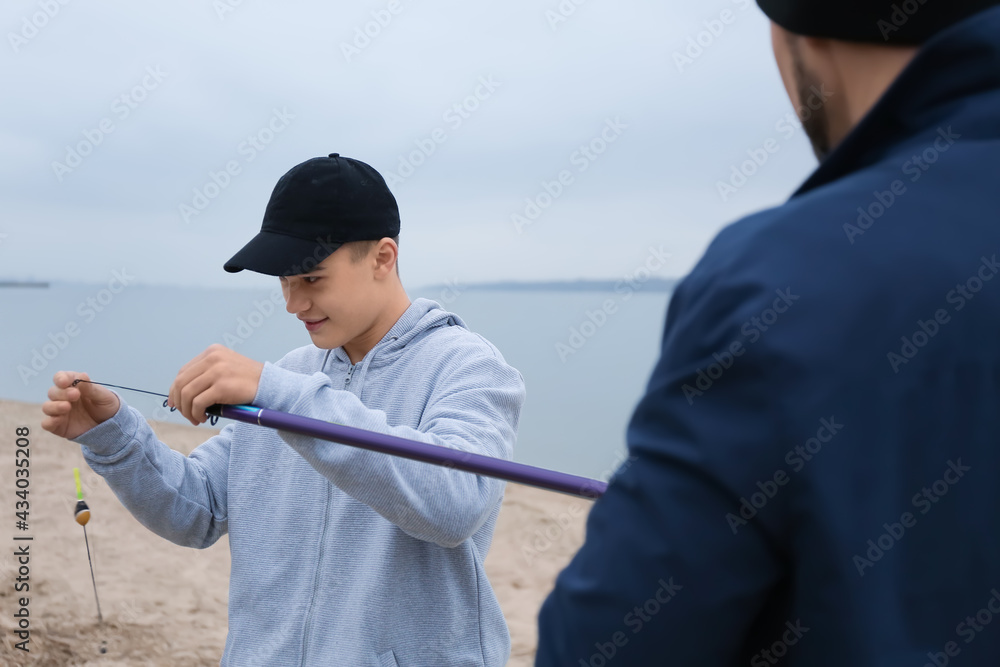 Father and son fishing together on river