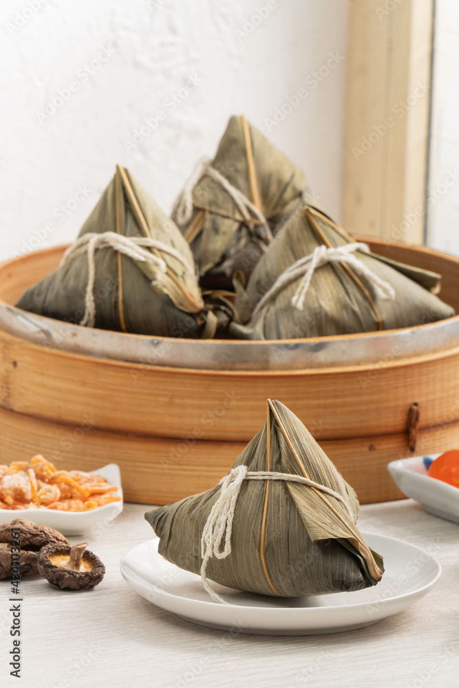 Zongzi. Rice dumpling for Dragon Boat Festival on bright wooden table background with window.