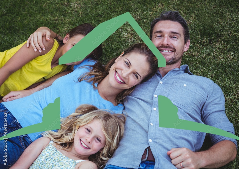 Happy caucasian family relaxing in the grass with home symbol