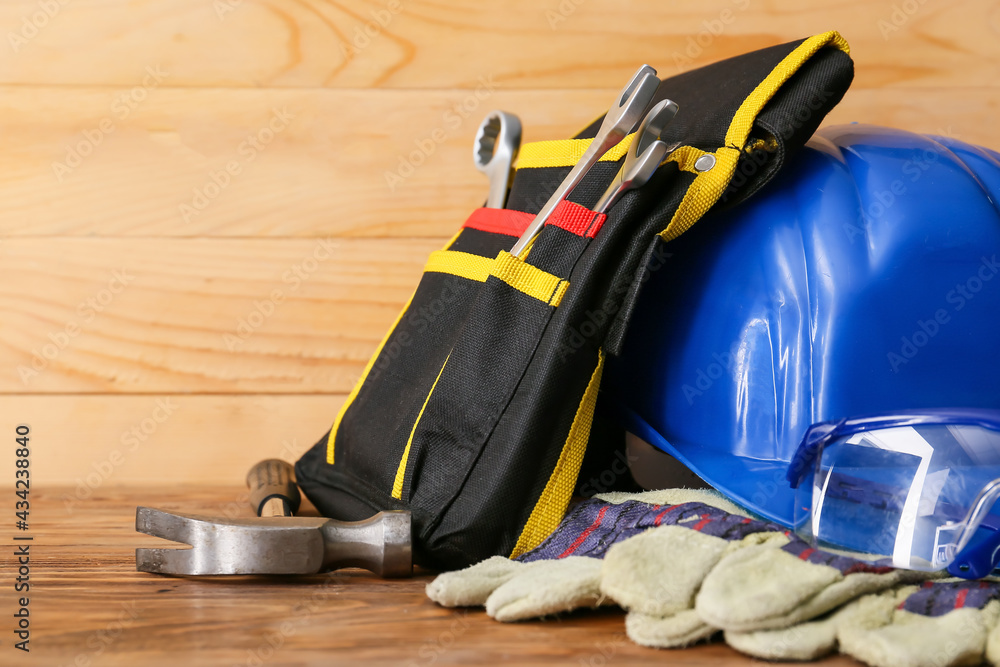 Bag with safety equipment on wooden background