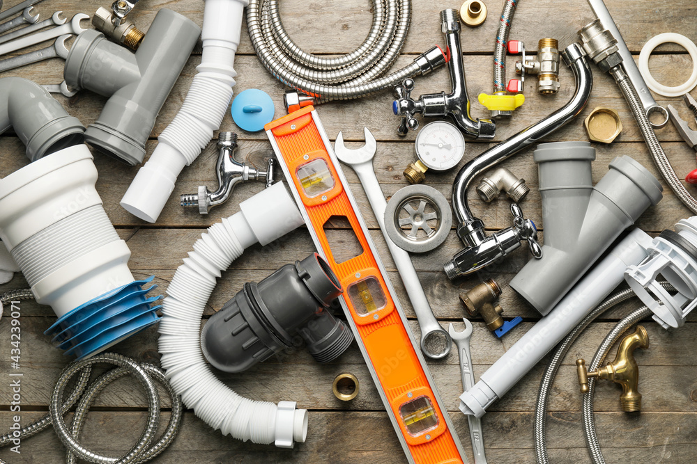 Set of plumbers items on wooden background