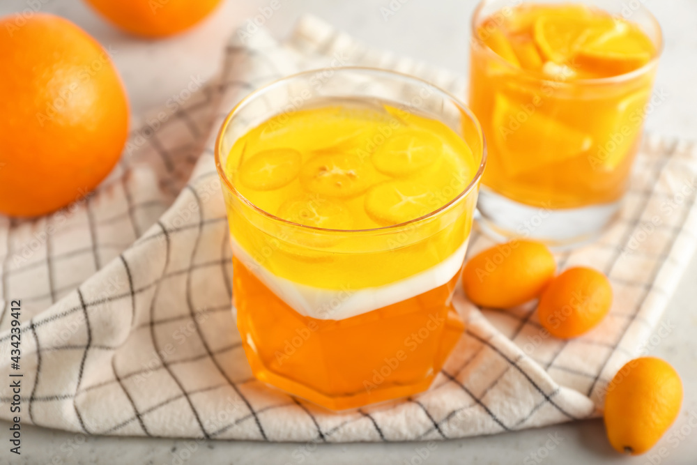 Glasses of tasty jelly on light background