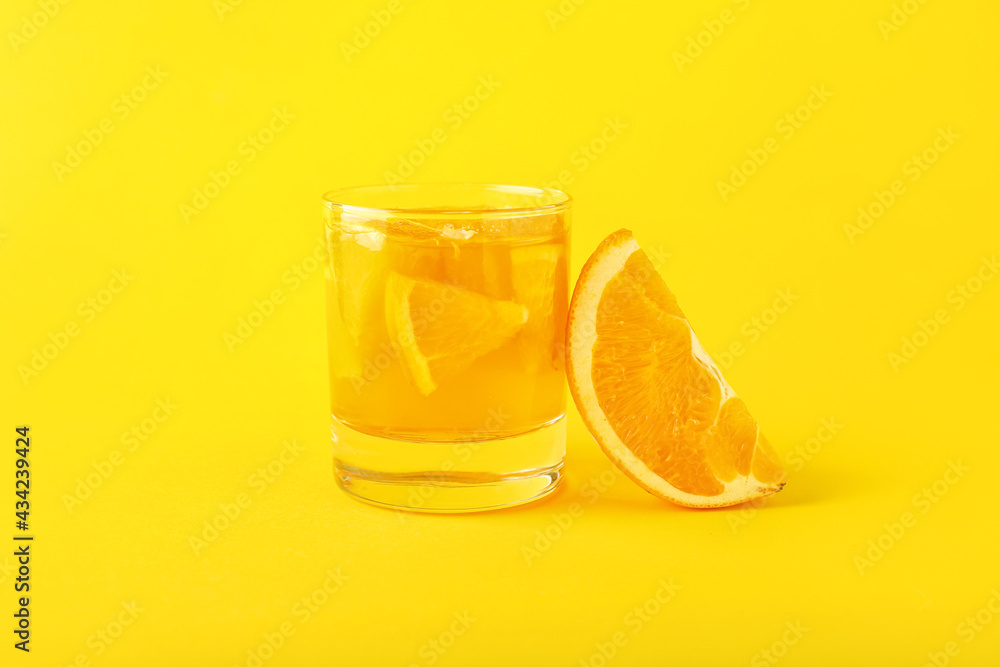 Glass of tasty orange jelly on color background