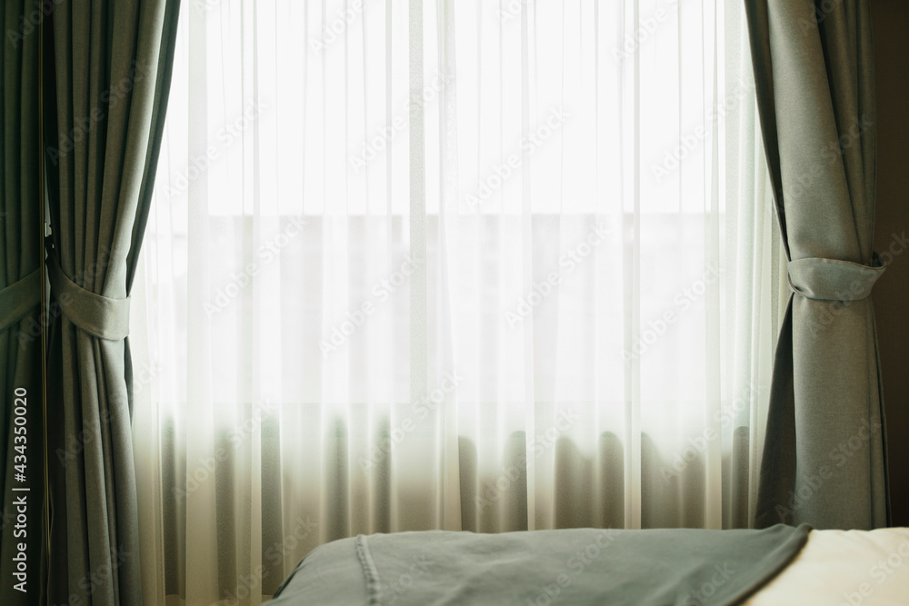 Glass window with white translucent curtain.Close up sheer curtain with beautiful sunlight in the mo