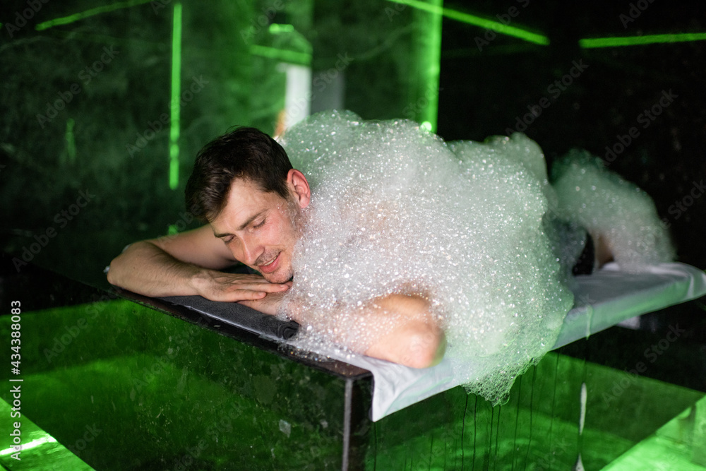 Man on the procedure of the foam massage in the hammam. Wellness and spa concept.