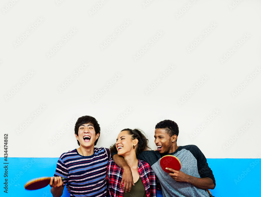 Group of diverse friends with table tennis rackets smiling cheerful