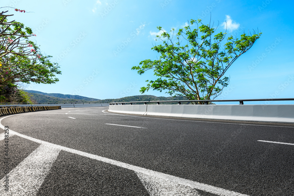 Mountain road landscape under blue sky.