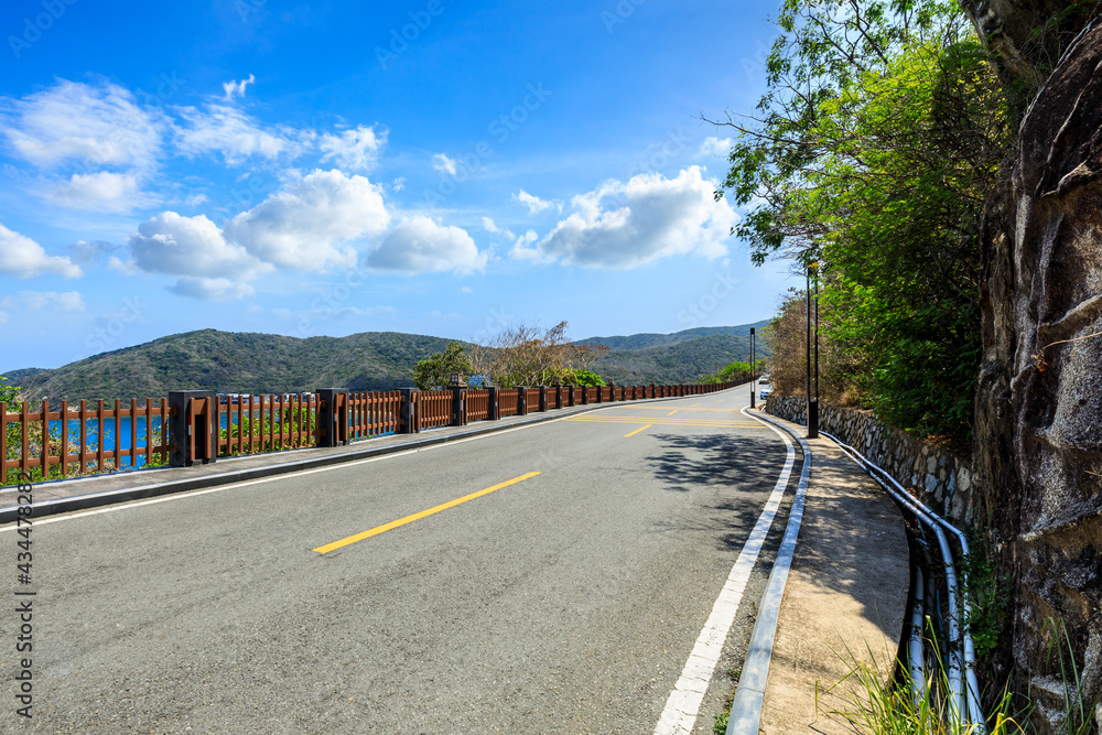 Mountain road landscape under blue sky.