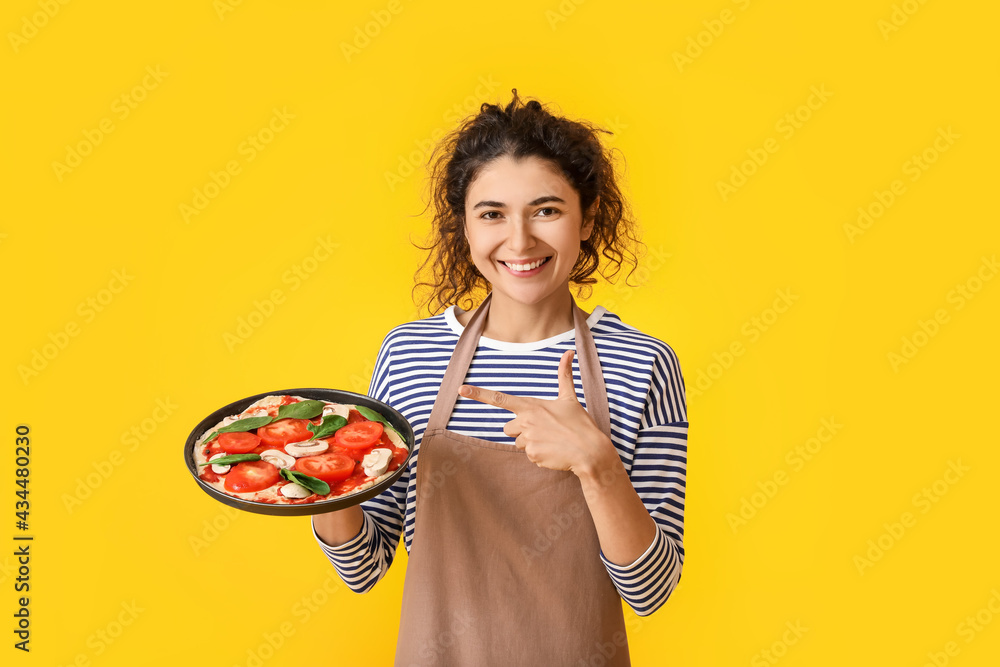 漂亮女人指着彩色背景上美味的披萨