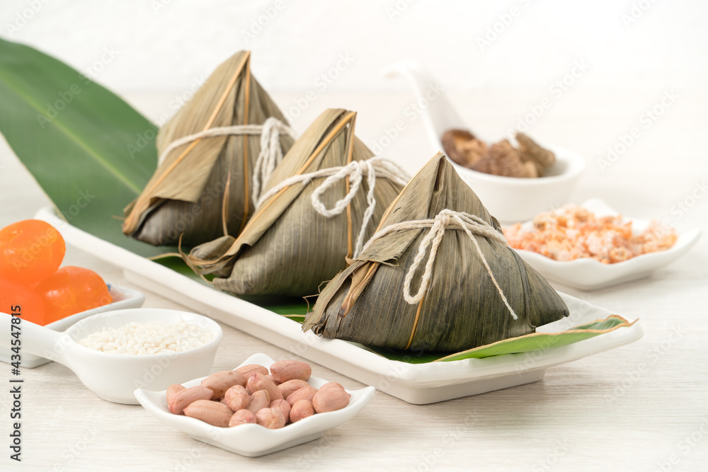 Zongzi. Rice dumpling for Dragon Boat Festival on bright wooden table background with ingredient.