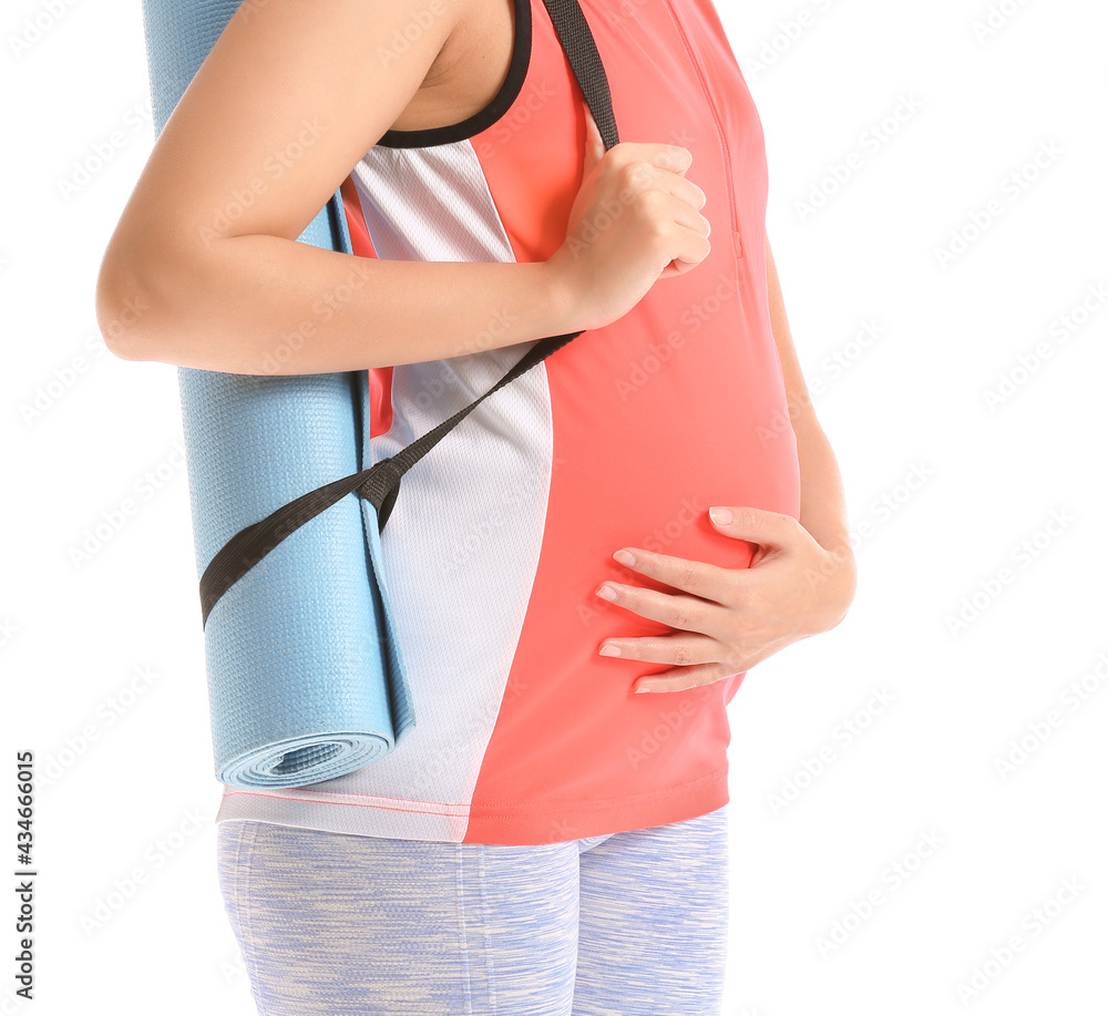 Young pregnant woman with yoga mat on white background