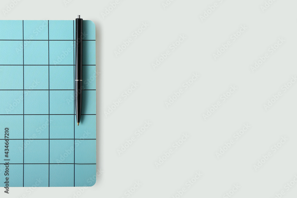 Checkered notebook and pen on white background