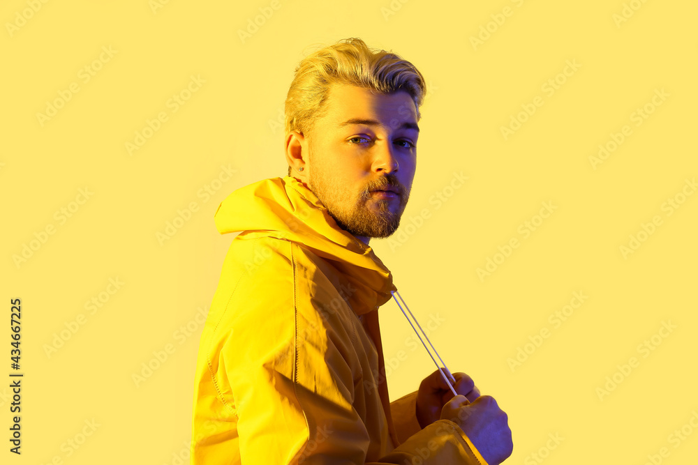 Toned portrait of handsome young man on color background