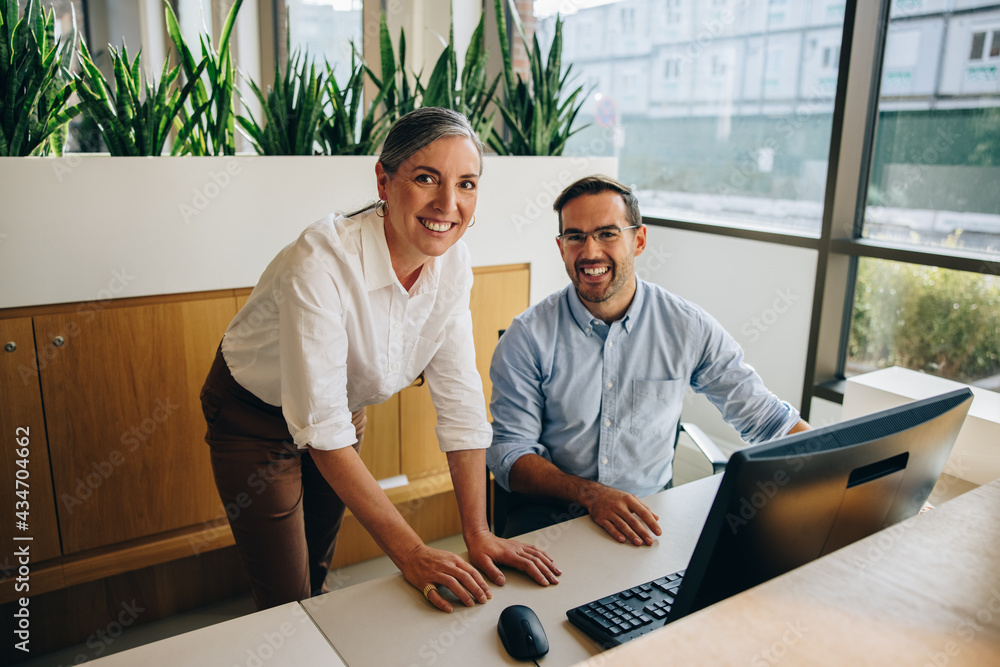 Manager with colleague smiling at camera