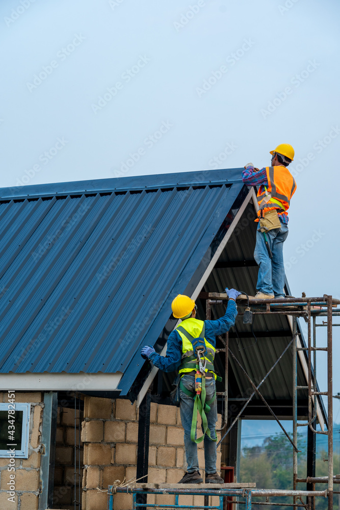 Roofer worker in protective uniform wear and gloves,Roofing tools,installing new roofs under constru