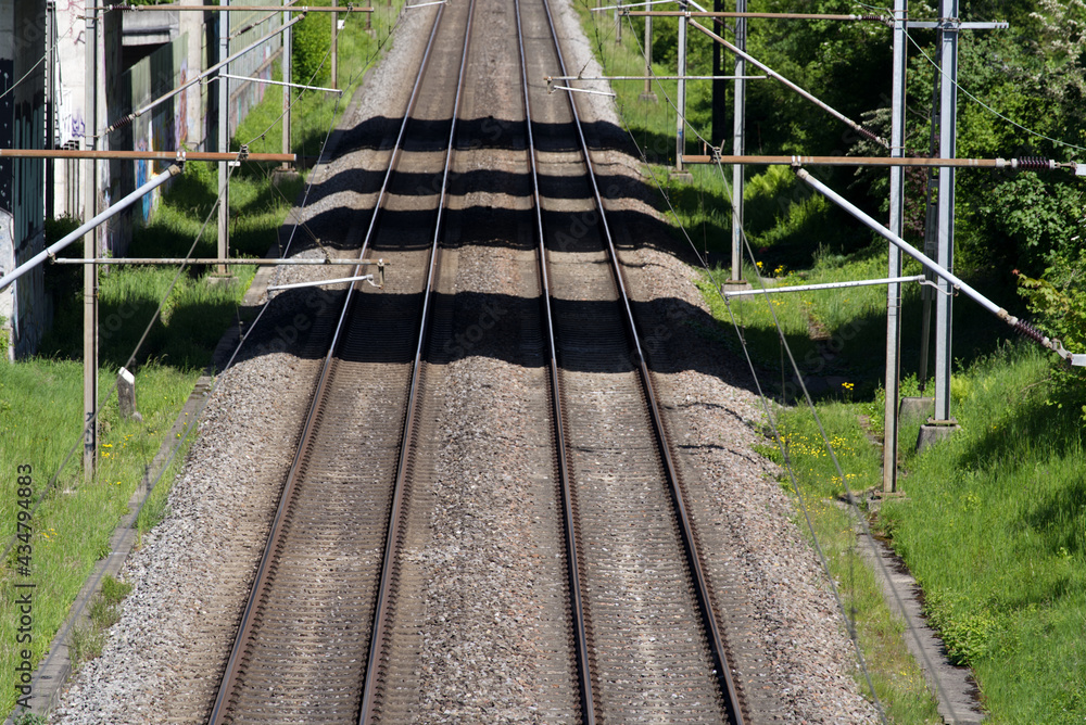 Empty railway tracks with shadows from bridge at springtime. Photo taken May 20th, 2021, Zurich, Swi