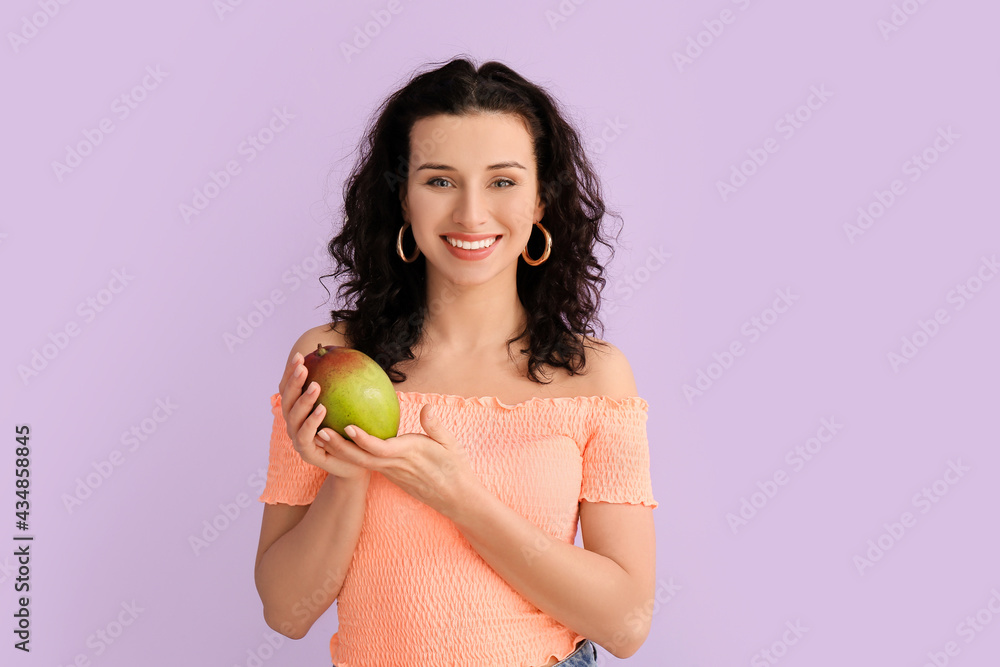 Beautiful woman with fresh mango on color background