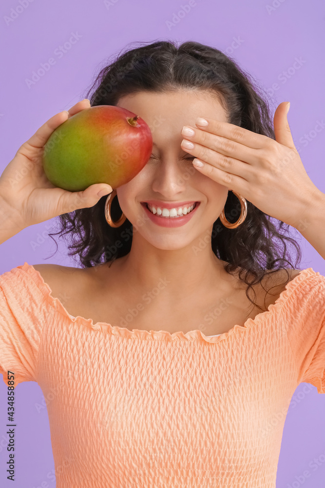 Beautiful woman with fresh mango on color background