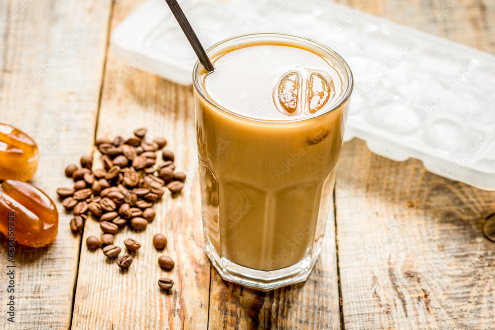 coffee ice cubes and beans with latte on wooden desk background