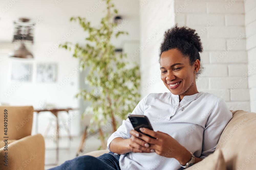 Smiling woman, relaxing at home, chatting with someone.