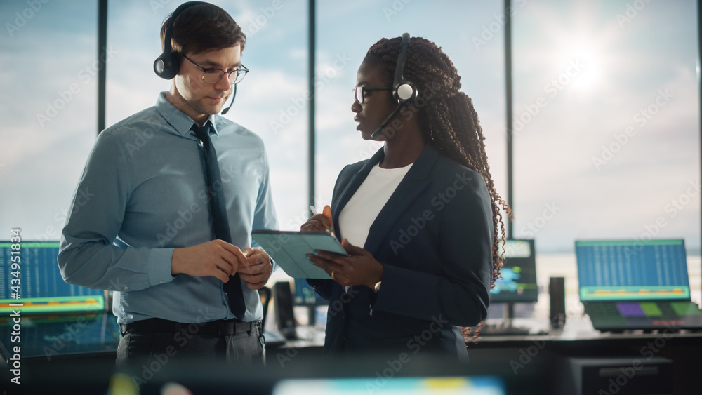 Female and Male Air Traffic Controllers with Headsets Talk in Airport Tower. Office Room is Full of 