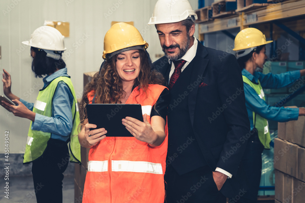 Warehouse senior manager discuss with worker in the storehouse . Logistics , supply chain and wareho