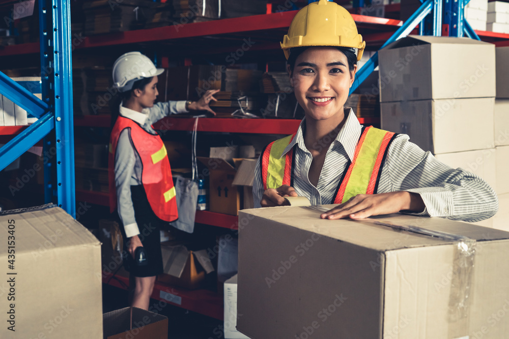 年轻的亚洲女仓库工人在仓库里微笑的肖像。物流，供应链