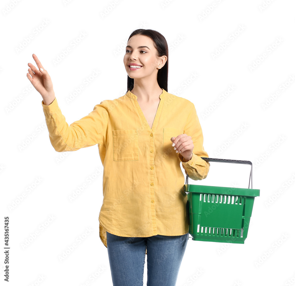 Young woman with shopping basket on white background