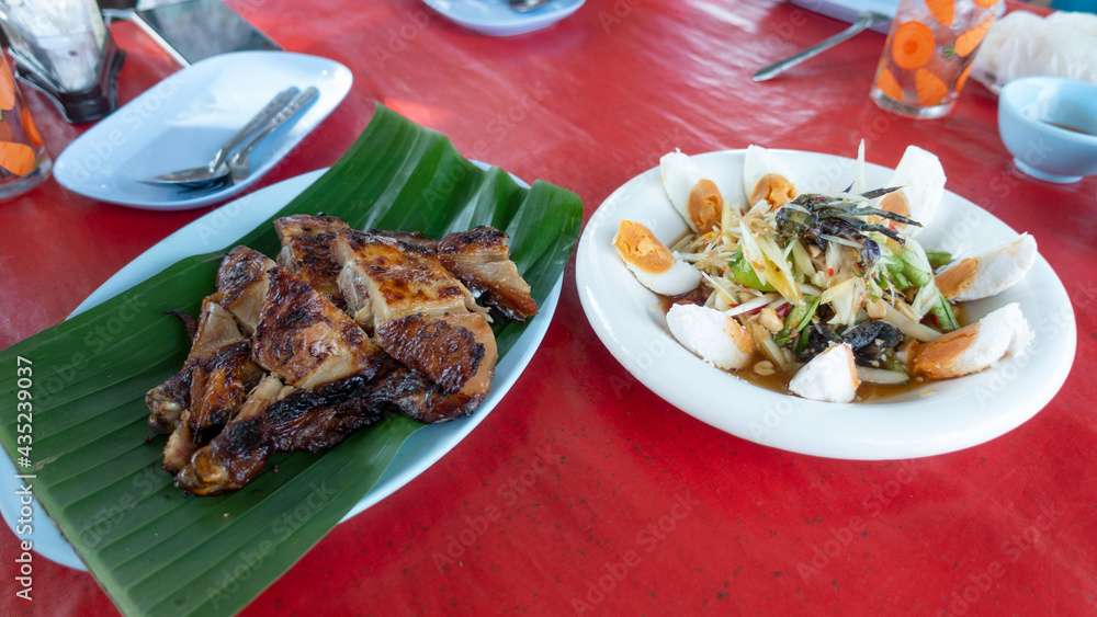 Papaya salad and grilled chicken thai food on table Popular Thai food