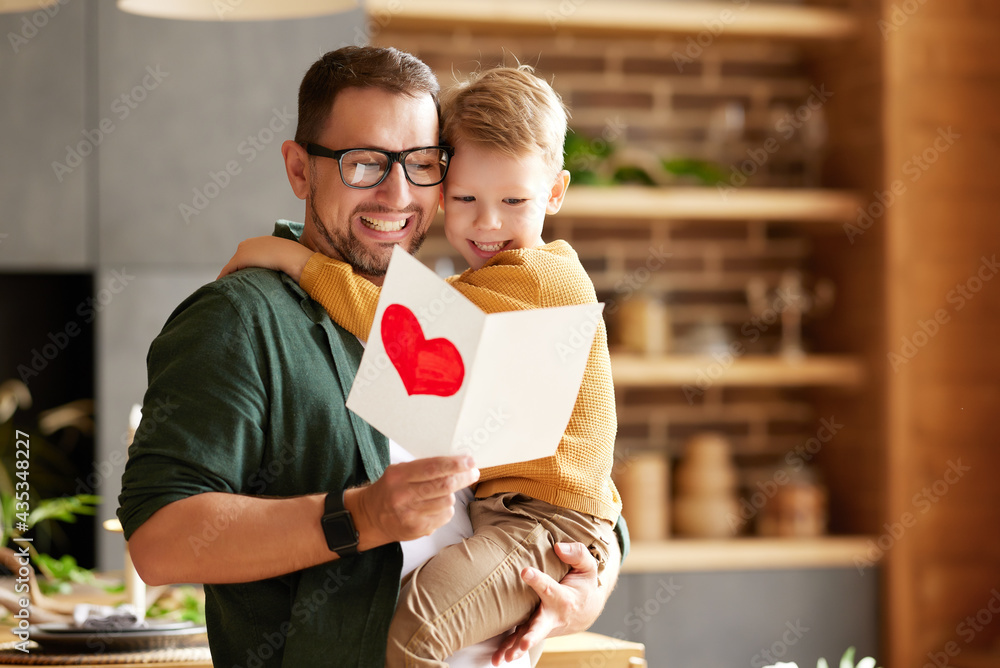 Cheerful father and son celebrating Fathers Day together at home