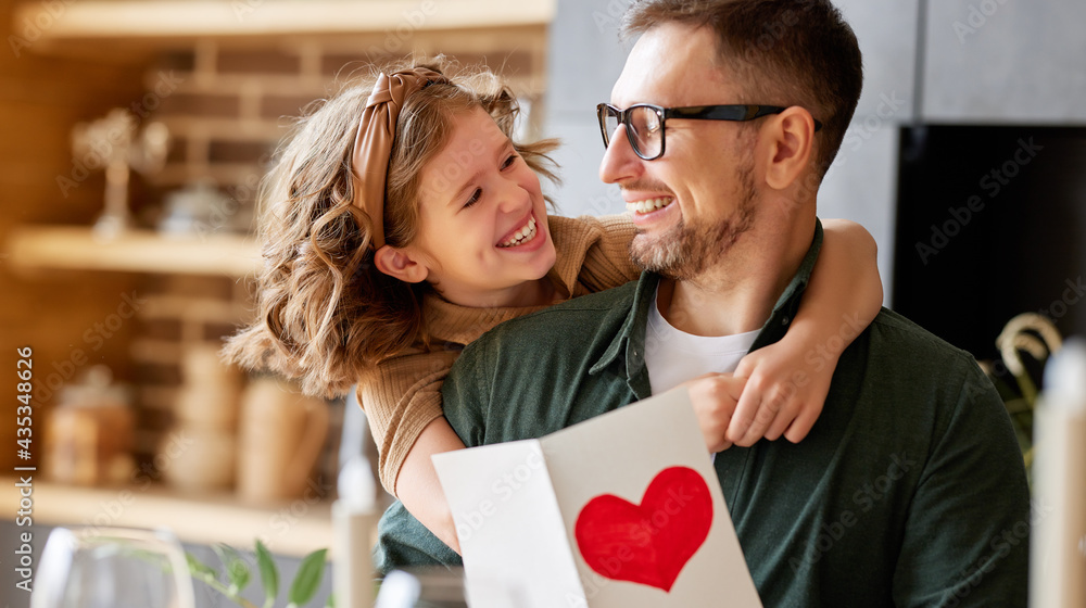 Cheerful father and daughter celebrating Fathers Day together at home